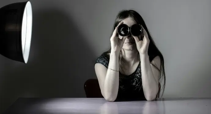 a woman sitting at a table with a camera in front of her